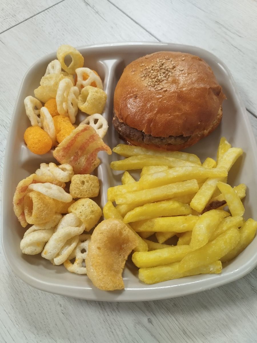 Menú infantil de hamburguesa con patatas fritas y snacks variados