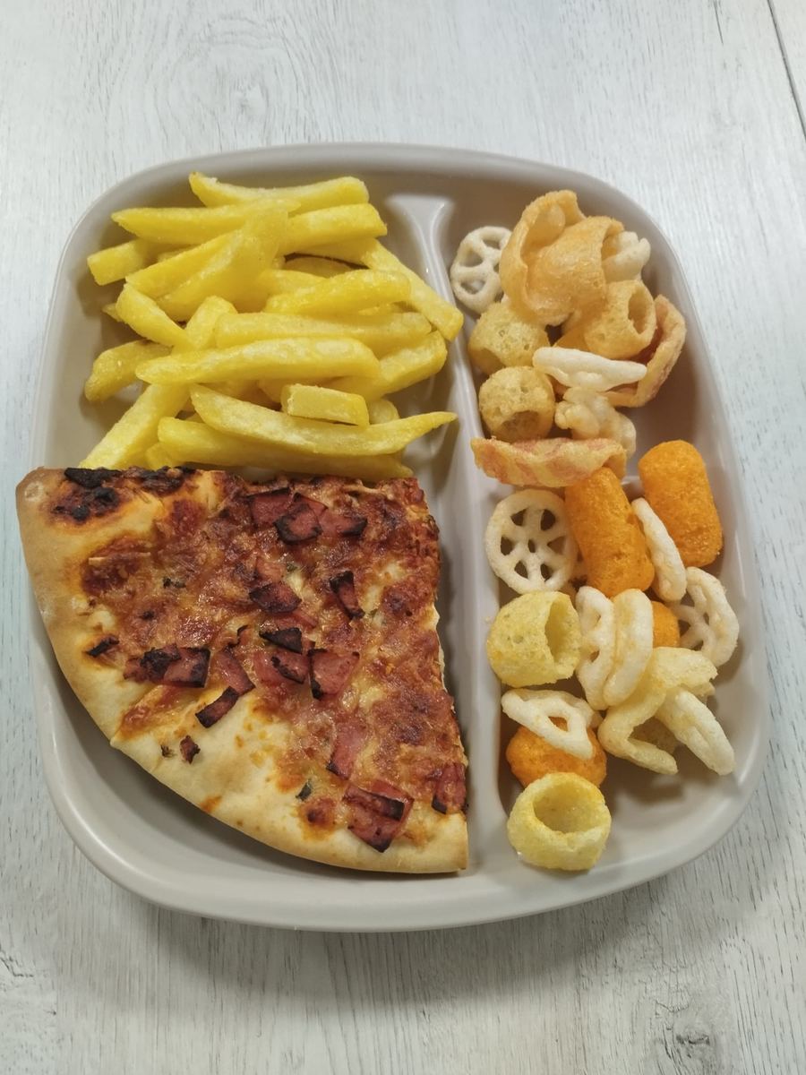 Menú infantil de pizza con patatas fritas y snacks variados